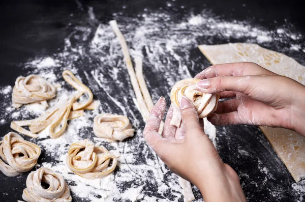En ung kvinna knådar pasta degen för hand — Stockfoto
