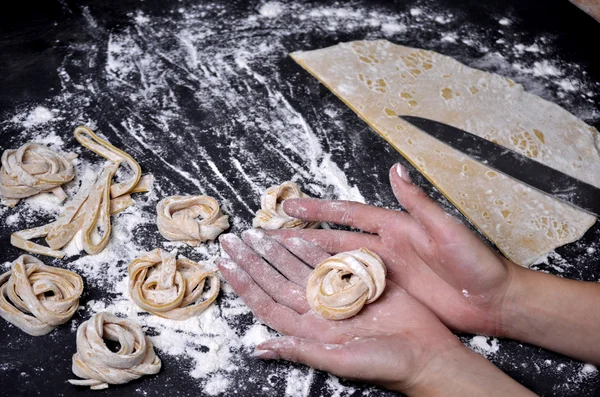 Een jonge vrouw kneedt pasta deeg met de hand — Stockfoto