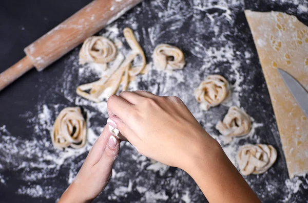 Een jonge vrouw kneedt pasta deeg met de hand — Stockfoto