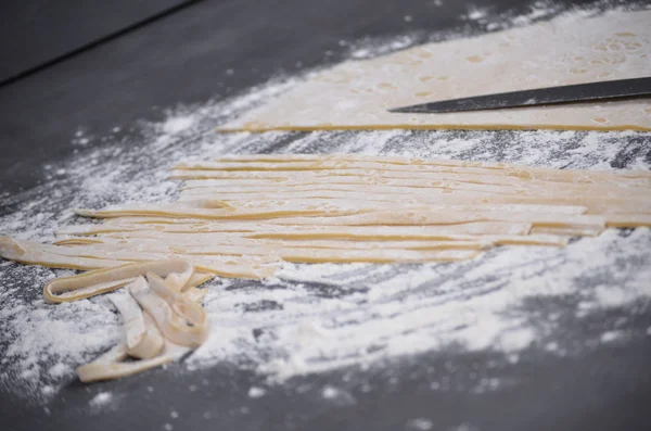 Een jonge vrouw kneedt pasta deeg met de hand — Stockfoto