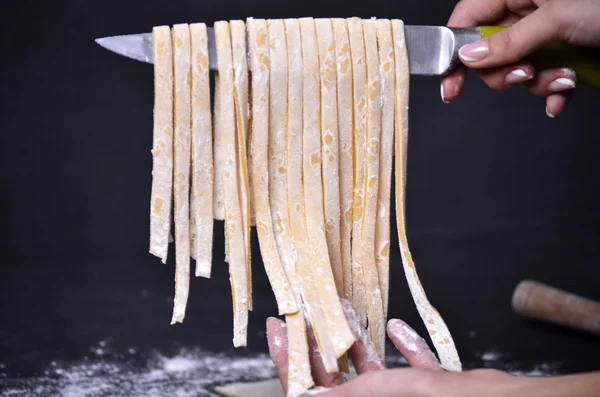 Genç bir kadın makarna hamur el ile kneads