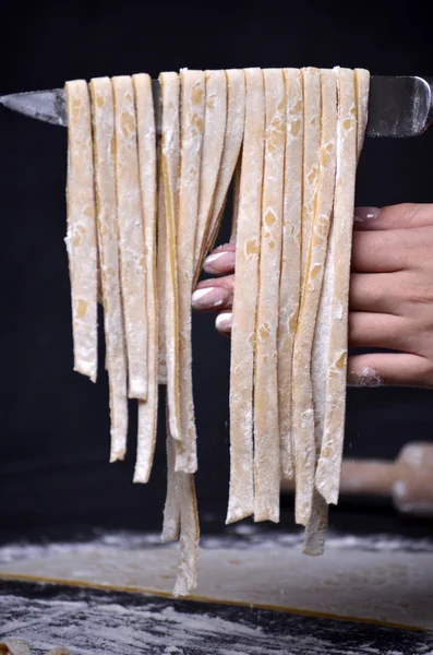 Genç bir kadın makarna hamur el ile kneads