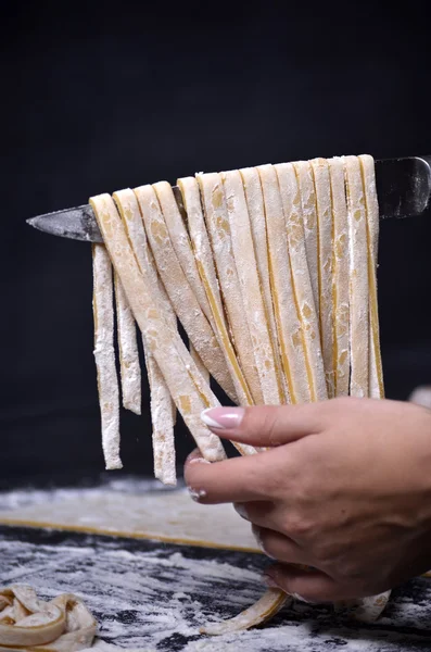 Een jonge vrouw kneedt pasta deeg met de hand — Stockfoto