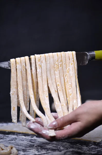 Genç bir kadın makarna hamur el ile kneads