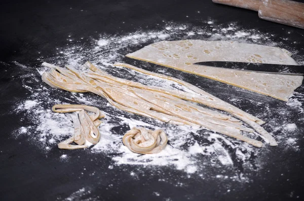 Een jonge vrouw kneedt pasta deeg met de hand — Stockfoto