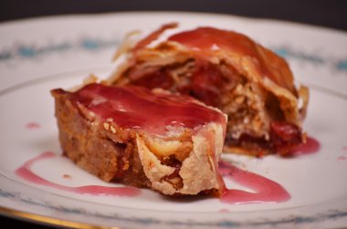 Kiraz yakın çekim ile ev yapımı meyveli turta bir tabağa dilimlenmiş.