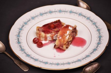 Kiraz yakın çekim ile ev yapımı meyveli turta bir tabağa dilimlenmiş.