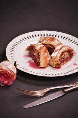 Kiraz yakın çekim ile ev yapımı meyveli turta bir tabağa dilimlenmiş.