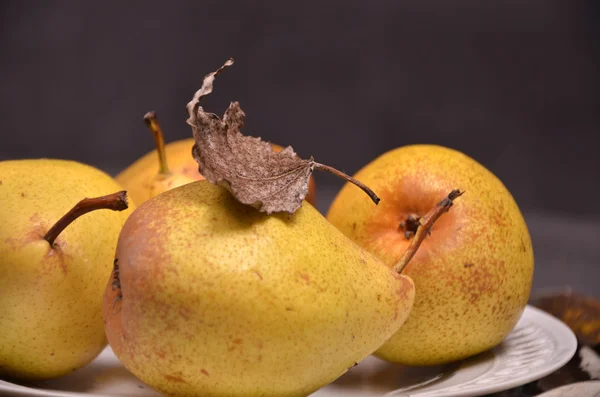 Birnen in einem hölzernen Korb auf einem hölzernen Hintergrund — Stockfoto