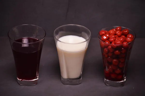 Стаканы с вишней, соком и молоком — стоковое фото