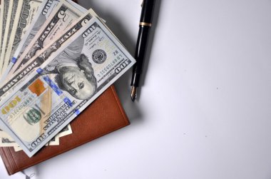 para, kalem ve beyaz arka plan üzerinde kahverengi defter