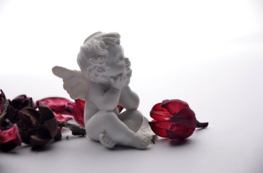 bir meleğin kırmızı gül yaprakları ile heykelciği
