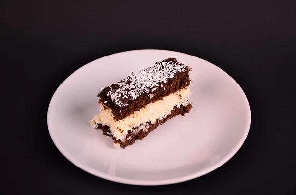 Cake bounty on white tale on black table — Stock Photo, Image