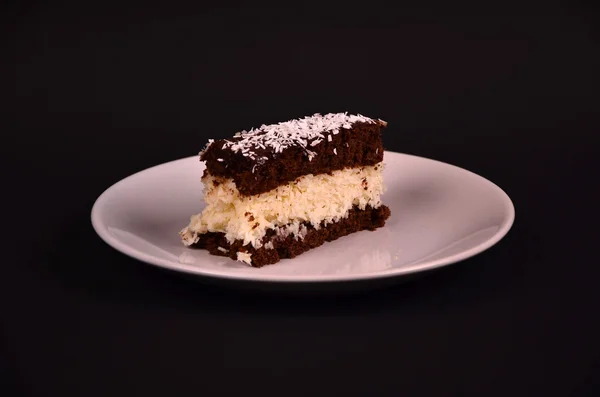 Cake bounty on white tale on black table — Stock Photo, Image
