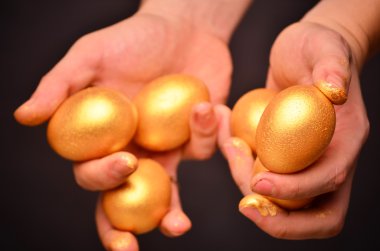 Man holding in hands a golden eggs - investment concept clipart