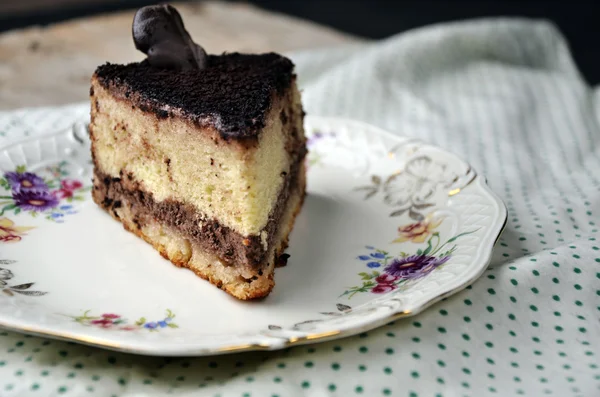 Ein leckeres süßes Stück Kuchen und eine Flasche Milch auf der Tischdecke — Stockfoto