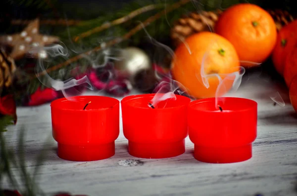 Κόκκινα κεριά με ligts Χριστούγεννα, χριστουγεννιάτικο δέντρο και μανταρίνια σε ατμοσφαιρικό φως — Φωτογραφία Αρχείου