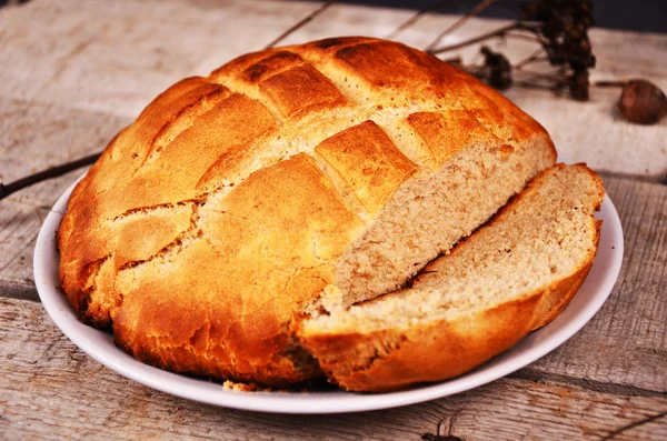 Čerstvě upečený bochník žitný chléb kynutého těsta podávané na rustikální dřevěný stůl. — Stock fotografie