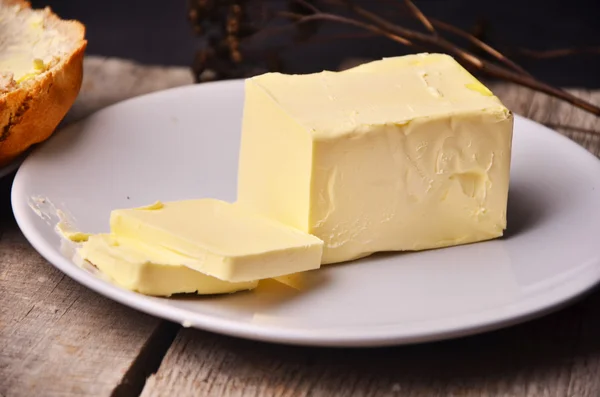小新鲜农场块黄油黄油碟用小刀上使用作为传播或咕咕叫成分，鸟瞰板条木制的桌子上 — 图库照片