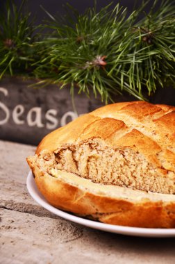 bir plaka ile yanındaki ahşap bir masa üzerinde beyaz bir plaka üzerinde taze ev yapımı ekmek buyyer yalan söylüyor. Noel