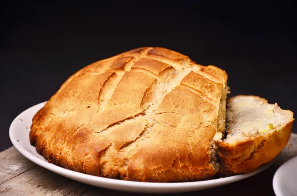 Pão redondo caseiro tradicional em um fundo preto — Fotografia de Stock