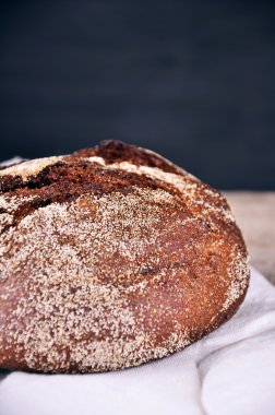 Masa örtüsü üzerinde yalan yuvarlak iyi kızarmış ekmek. Ev yapımı ekmek.