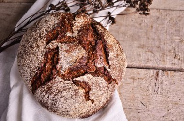 Masa örtüsü üzerinde yalan yuvarlak iyi kızarmış ekmek. Ev yapımı ekmek.