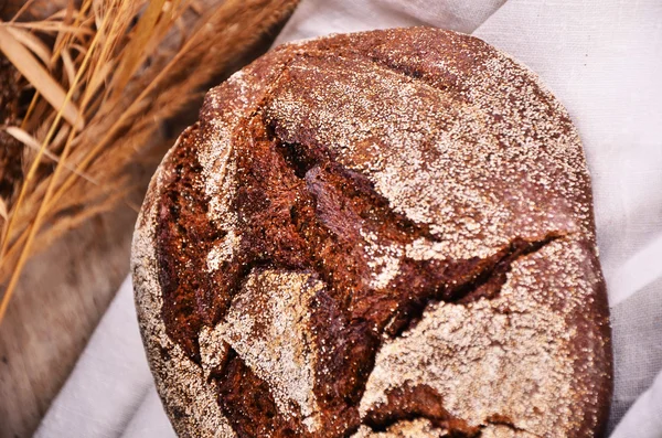 Bochník chleba na dřevěné pozadí, potraviny detail — Stock fotografie