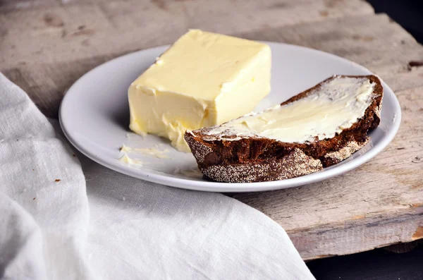 Pain frais et beurre fait maison sur fond de bois — Photo