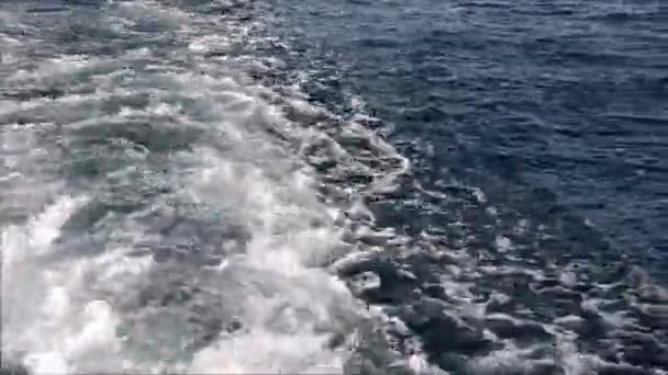 Blue sea water passing view from a moving boat with sparkles and light reflections — Stock Video