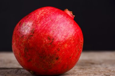 Bütün nar ahşap bir masa üzerinde. Arka plan kaybolur brown dan siyaha kopya alanı ile