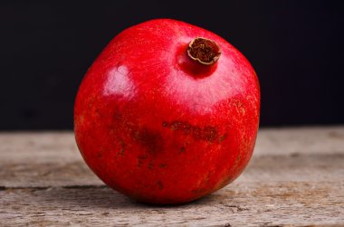 Bütün nar ahşap bir masa üzerinde. Arka plan kaybolur brown dan siyaha kopya alanı ile