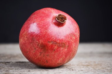 Bütün nar ahşap bir masa üzerinde. Arka plan kaybolur brown dan siyaha kopya alanı ile