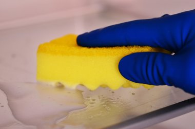 Kadın eli mavi kauçuk koruyucu eldiven sarı bez ile temizlik beyaz açık boş buzdolabı. Temizlik kavramı. Temiz