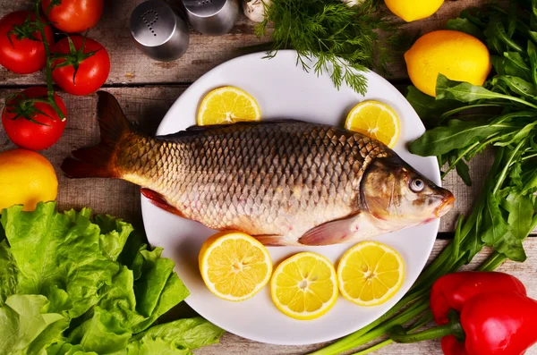 Pescado fresco Cyprinus carpio carpio con las verduras y el limón —  Fotos de Stock