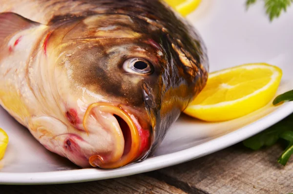 Pescado fresco Cyprinus carpio carpio con las verduras y el limón —  Fotos de Stock