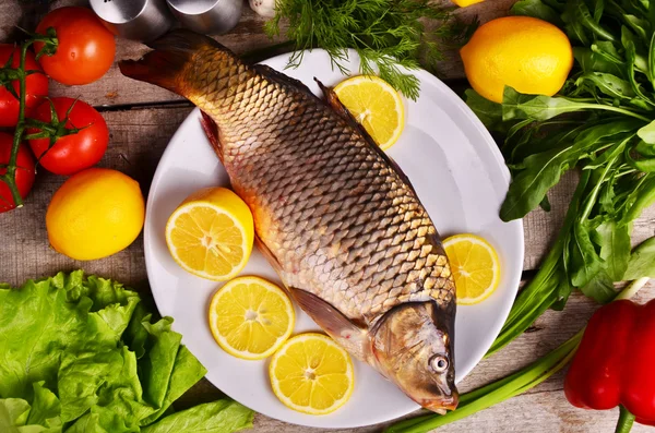 Pescado fresco Cyprinus carpio carpio con las verduras y el limón —  Fotos de Stock