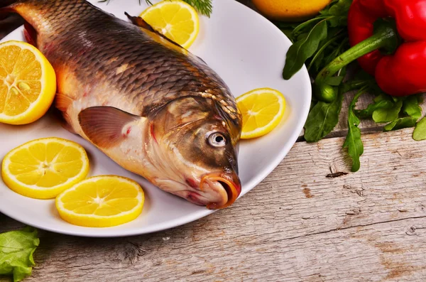Pescado fresco Cyprinus carpio carpio con las verduras y el limón —  Fotos de Stock