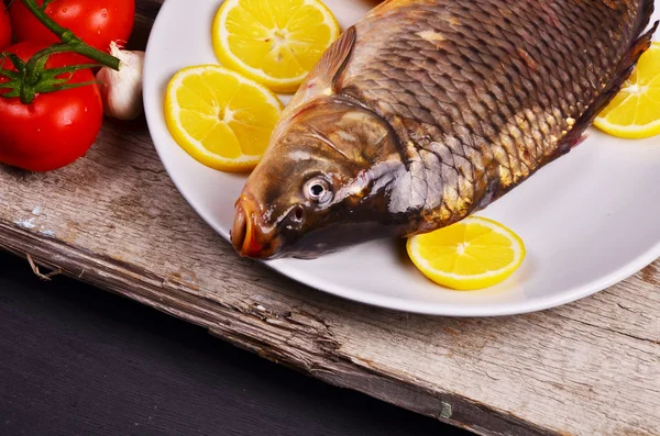 Pescado fresco Cyprinus carpio carpio con las verduras y el limón —  Fotos de Stock