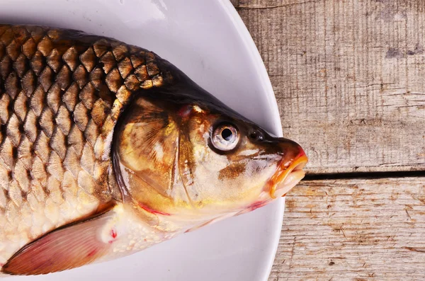 Rå fisk med citron på pannan och på ett bord — Stockfoto