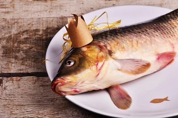 crucian carp  With a crown on wooden table. creative concept. King of fish