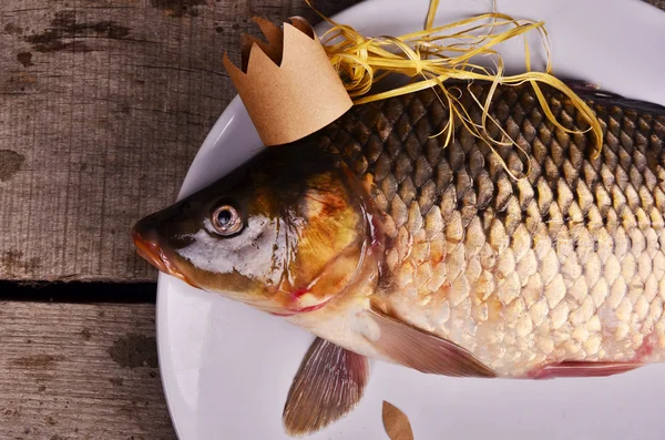 crucian carp  With a crown on wooden table. creative concept. King of fish