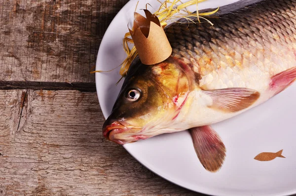 crucian carp  With a crown on wooden table. creative concept. King of fish