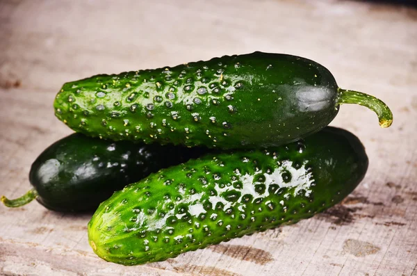 Cucumber on wooden plate and vintage background. Selective focus on cucumber — Stock Photo, Image