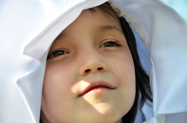 Süßes kleines Mädchen im Freien mit Mantel auf dem Kopf — Stockfoto
