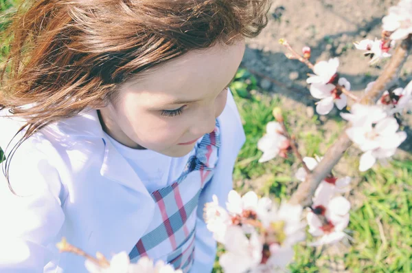Fröhliches Kind, das im Garten spielt und auf den Baum klettert. Frühling — Stockfoto