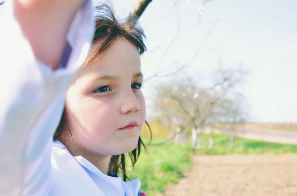 Süßes kleines Mädchen im Freien mit lockigem Haar im Wind — Stockfoto