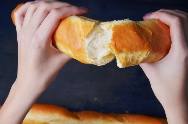 Pão baguete em sua mão em um fundo branco — Fotografia de Stock