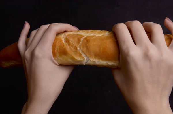 Хлебный багет в руке на белом фоне — стоковое фото
