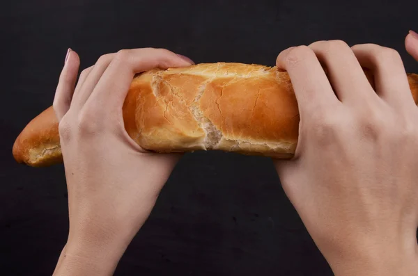Bagietka chleb w jego ręce na białym tle — Zdjęcie stockowe